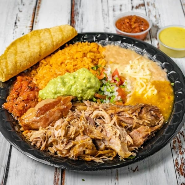 Bandeño Mexican Food plate with shredded pork, rice, beans, guacamole, salsa, and a fried taco.